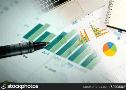 Financial graphs analysis and pen.Business Concept