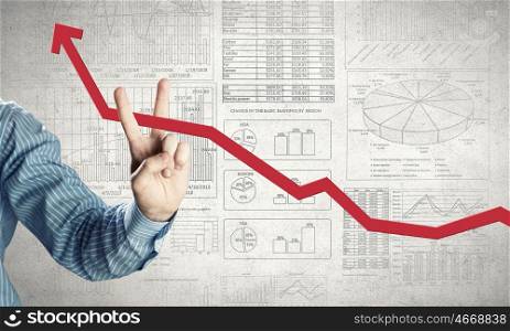 Financial growth. Hand holding cutting with fingers rising arrow representing business growth