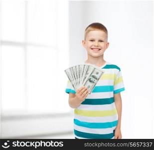 financial, planning, childhood and concept - smiling boy holding dollar cash money in his hand over white room background
