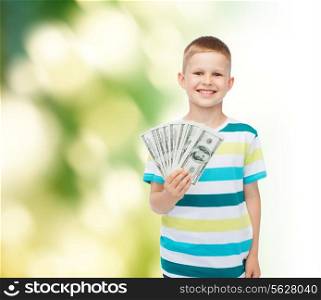 financial, planning, childhood and ecology concept - smiling boy holding dollar cash money in his hand over green background