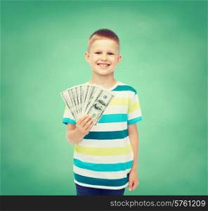 financial, planning, childhood and educational concept - smiling boy holding dollar cash money in his hand over green board background