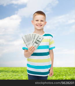 financial, planning, childhood and environment concept - smiling boy holding dollar cash money in his hand over natural background
