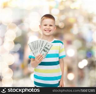 financial, planning, childhood and holidays concept - smiling boy holding dollar cash money in his hand over sparkling background