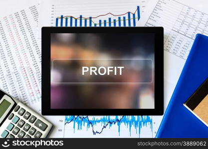 financial profit word on tablet with financial graph background