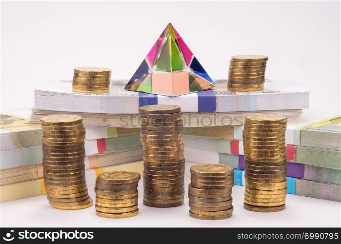 Financial pyramid, wads of money and stacks of coins