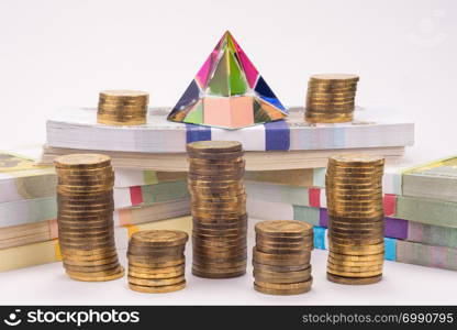Financial pyramid, wads of money and stacks of coins