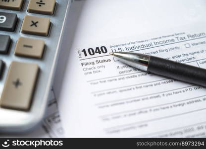 Financial time tax return forms with pen and calculator