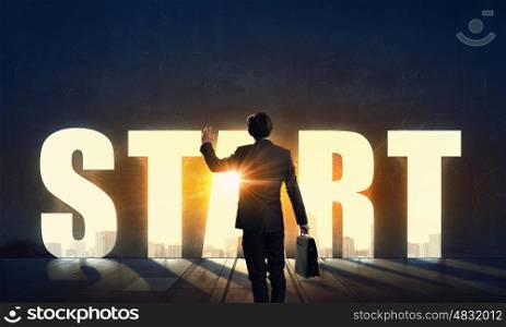 Find your business motivation. Back view of businessman standing in light of conceptual word
