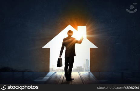 Find your business motivation. Back view of businessman standing in light of doorway