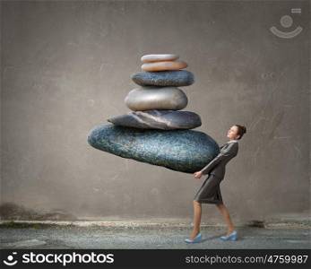 Find your inner balance. Attractive businesswoman carrying stack of stones in hands