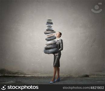 Find your inner balance. Attractive businesswoman carrying stack of stones in hands
