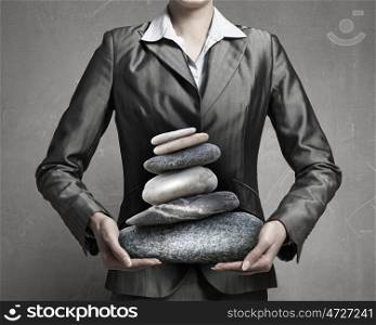 Find your inner balance. Close view of businesswoman holding stack of stones in hands