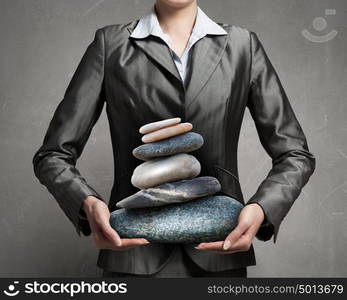 Find your inner balance. Close view of businesswoman holding stack of stones in hands