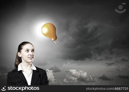 Find your inspiration. Concept of creativity with woman and light bulb hanging from above