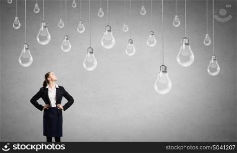 Find your inspiration. Concept of creativity with woman and light bulbs hanging from above