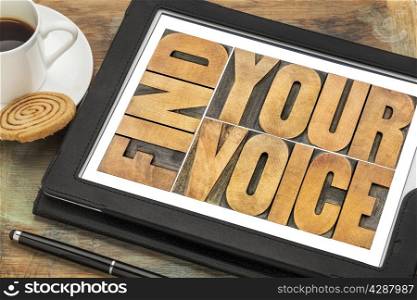 find your voice creativity concept - word abstract in letterpress wood type on a digital tablet with a cup of coffee