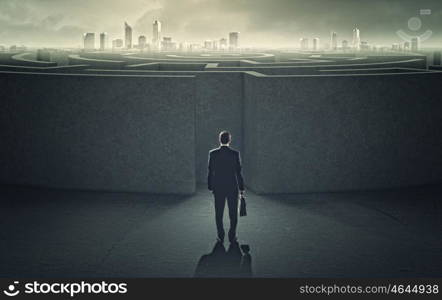 Finding solution. Businessman standing near the enter of labyrinth