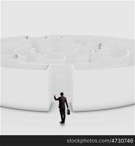 Finding solution. Businessman standing near the enter of labyrinth
