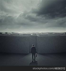 Finding solution. Businessman standing near the enter of labyrinth