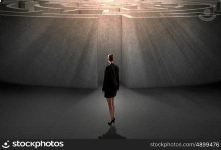 Finding solution. Businesswoman standing near the enter of labyrinth