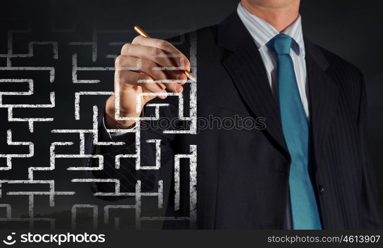 Finding solution. Close up of businessman drawing way out of labyrinth