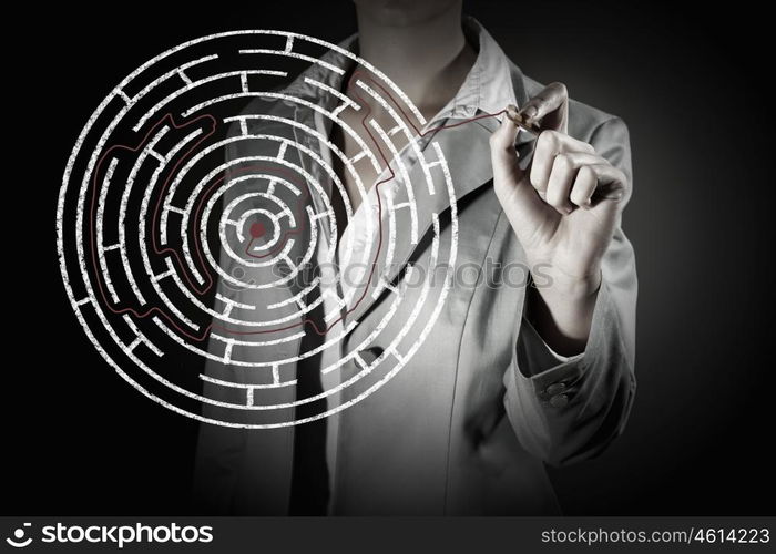 Finding solution. Close up of businessman drawing way out of labyrinth