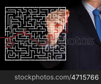 Finding solution. Close up of businessman drawing way out of labyrinth