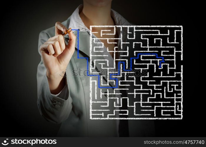 Finding solution. Close up of businessman drawing way out of labyrinth