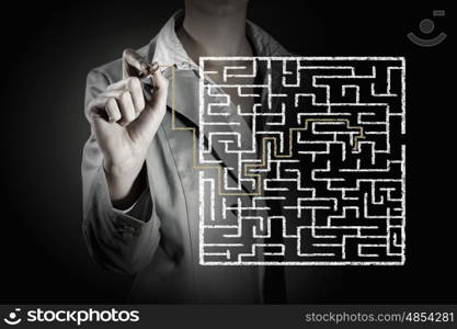 Finding solution. Close up of businessman drawing way out of labyrinth