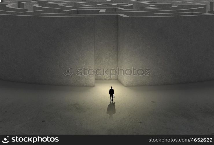 Finding solution!. Puzzled businessman standing near entrance of labyrinth