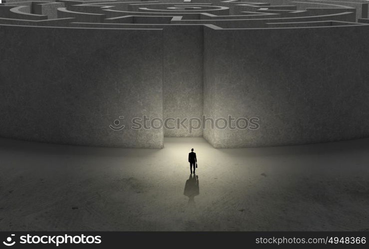 Finding solution!. Puzzled businessman standing near entrance of labyrinth