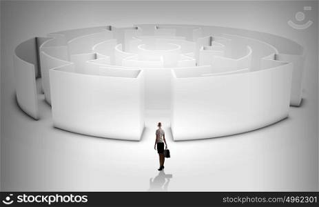Finding solution!. Puzzled businesswoman standing near entrance of labyrinth