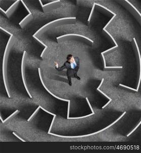 Finding solution. Top view of businessman standing in center of labyrinth