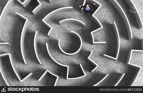 Finding the solution. Top view of successful businessman lost in labyrinth