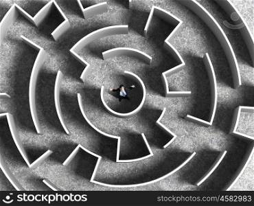 Finding the solution. Top view of successful businessman standing in center of labyrinth