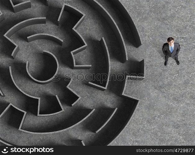 Finding the solution. Top view of successful businessman standing near the entrance of labyrinth