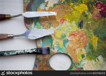 fine art, creativity and artistic tools concept - close up of palette knives or painting spatulas and paintbrush from top. palette knives or painting spatulas and brush