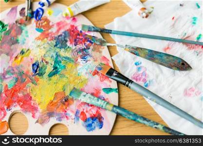 fine art, creativity and artistic tools concept - palette knives or painting spatulas and paintbrushes from top. palette knives or painting spatulas and brushes
