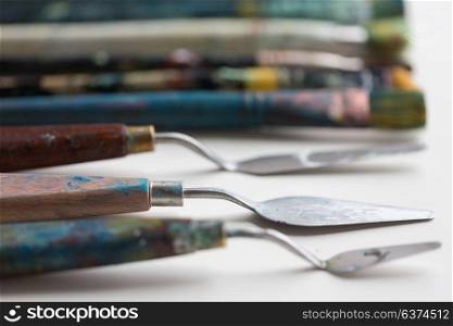 fine art, creativity and artistic tools concept - palette knives or painting spatulas and paintbrushes. palette knives or painting spatulas and brushes
