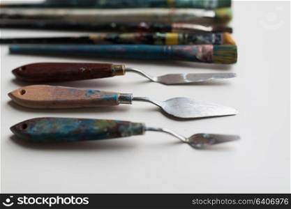 fine art, creativity and artistic tools concept - palette knives or painting spatulas and paintbrushes. palette knives or painting spatulas and brushes