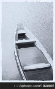Fine art image in black & white. A wooden boat on a misty lake.