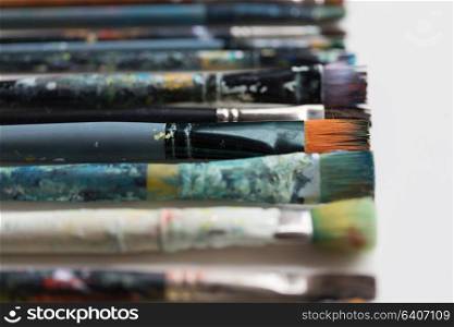 fine art, painting, creativity and artistic tools concept - close up of dirty paintbrushes. close up of dirty paintbrushes