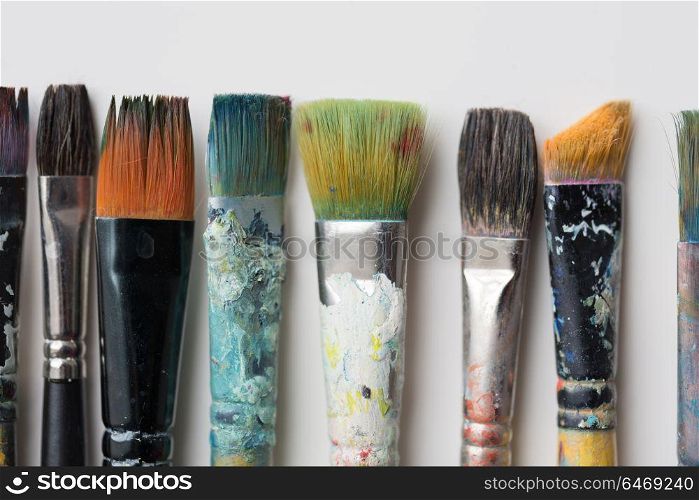 fine art, painting, creativity and artistic tools concept - close up of dirty paintbrushes from top. close up of dirty paintbrushes from top