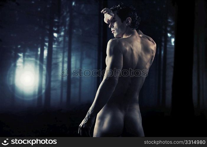 Fine art photo of a young muscular man in a forest