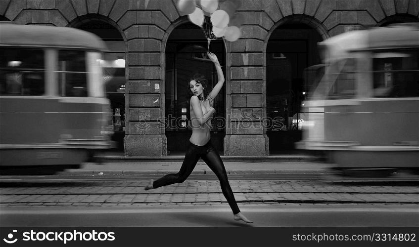 Fine art photo- young woman holding balloons in a empty city street