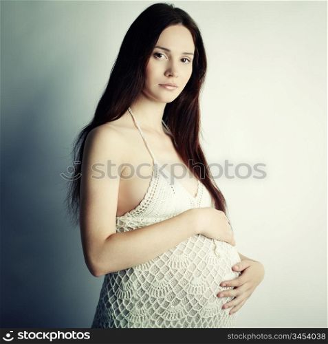 Fine art portrait of young pregnant woman