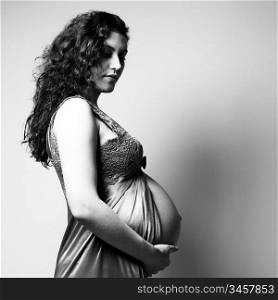Fine art portrait of young pregnant woman. Studio photo.