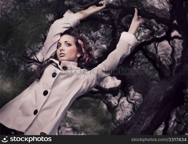 Fine ART style photo of a gorgeous brunette holding branch