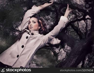 Fine ART style photo of a gorgeous brunette holding branch