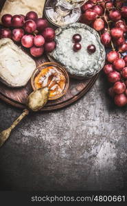 Fine cheese variety with wine, grapes and honey sauces on vintage background, top view, border. Dark style